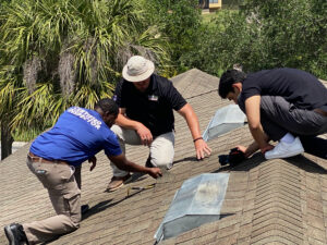 RoofMaxx technicians and licensed FL building inspector examine increased flexibility of asphalt shingle after RoofMaxx aplication.