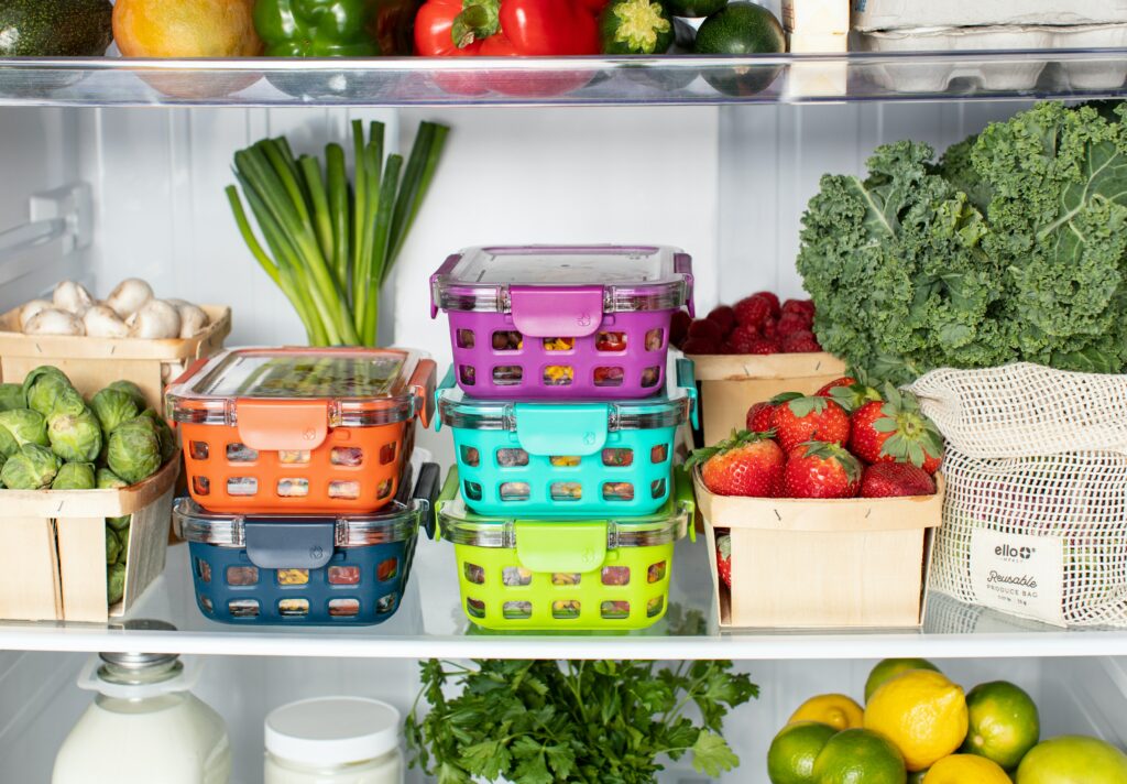 Open refrigerator door showing eco-friendly reusable/recycled containers.